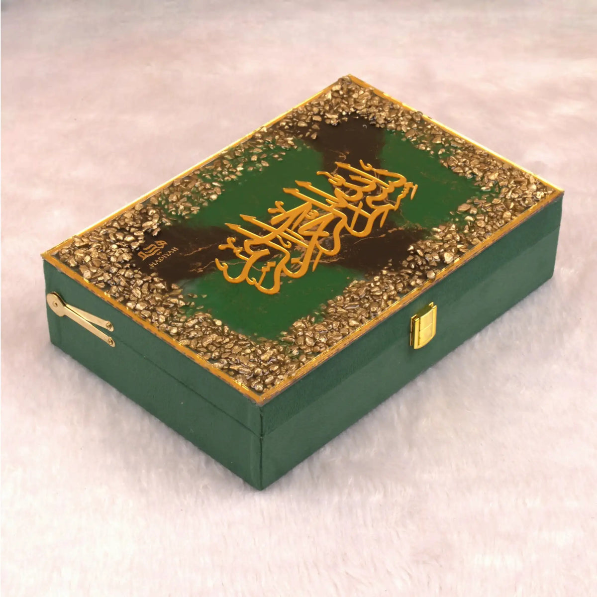 Decorative green box with gold embellishments on a light pink background
