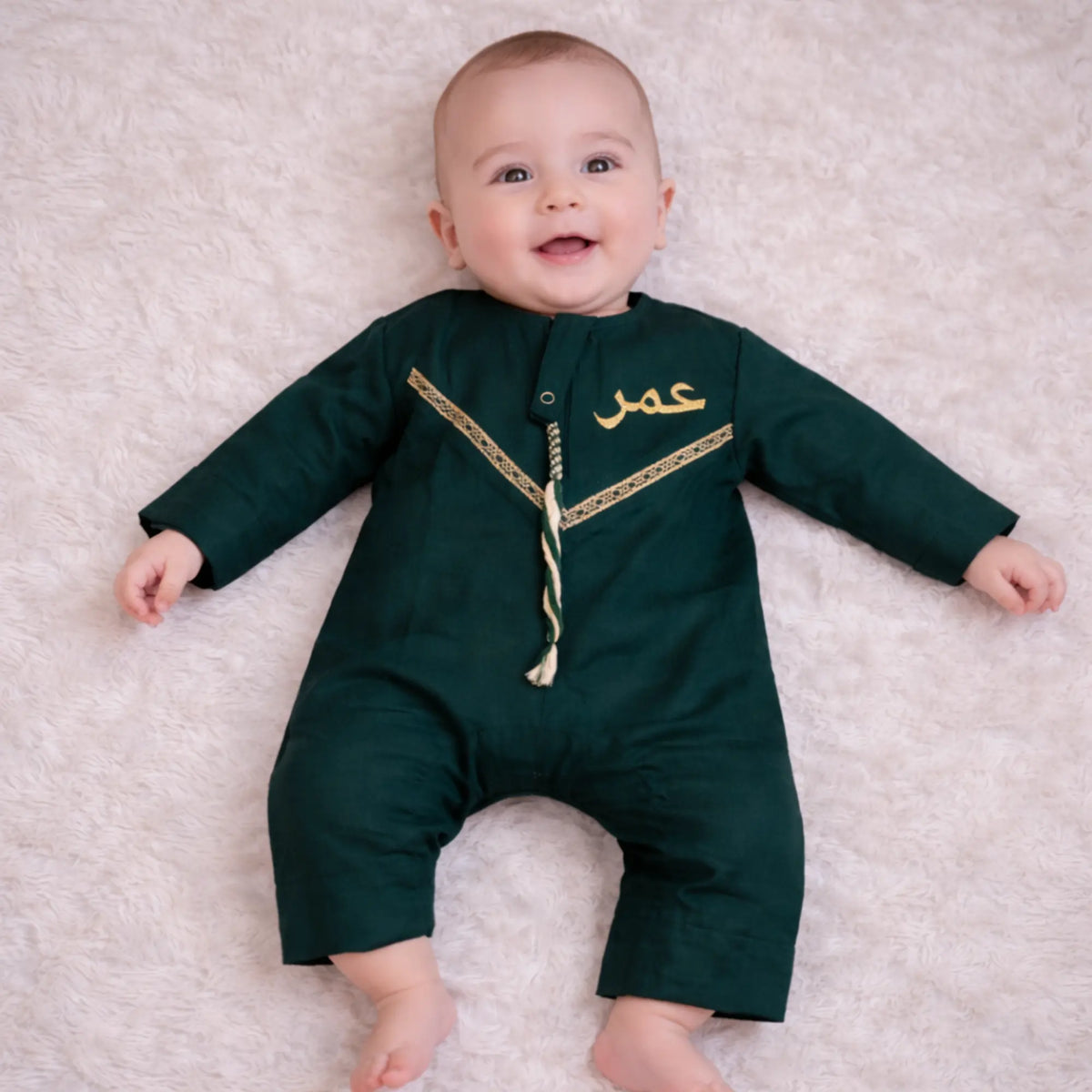 Baby boy in green traditional Islamic outfit for Eid