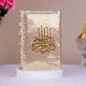 Decorative item with gold sequin cover and Arabic calligraphy on a white surface.