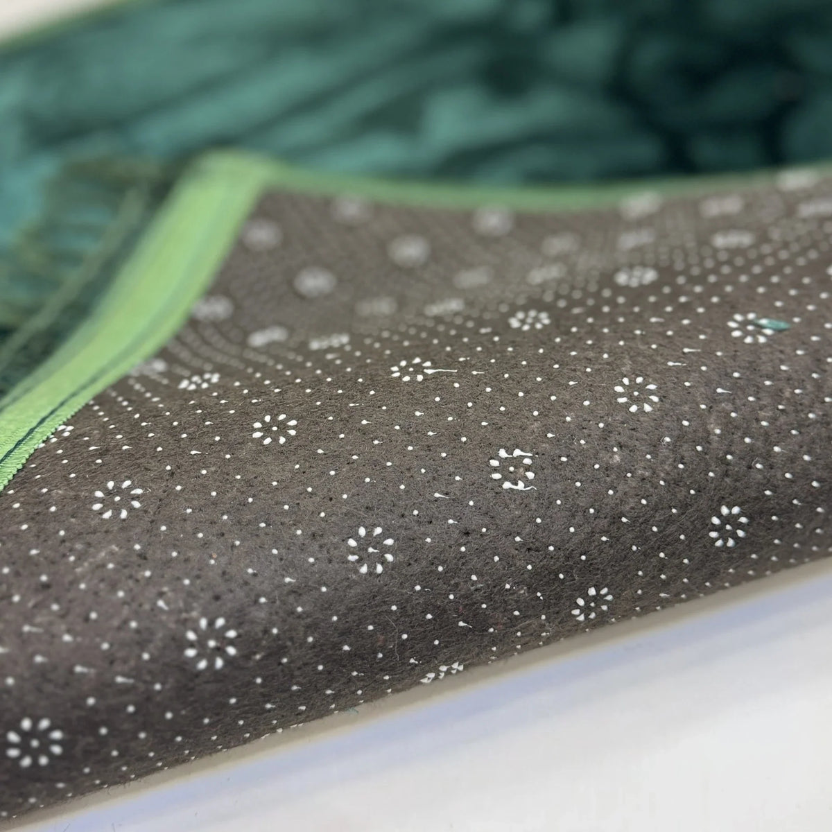 Non-slip backing of green Janamaz from the Couple Janamaz Set, featuring dotted grip for stability and comfort during prayer.