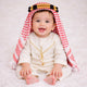 Baby boy wearing traditional white thobe with red checkered headscarf