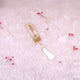 Decorative bookmark with tassel on a soft pink background