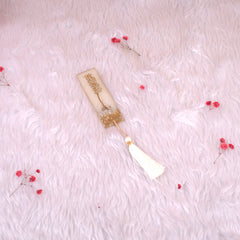 Gold-detailed Islamic bookmark with tassel from Kids Quran Gift Set. Complements Quran reading for children during special occasions.