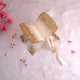Decorative lamp with gold embellishments on a soft pink background with flowers.