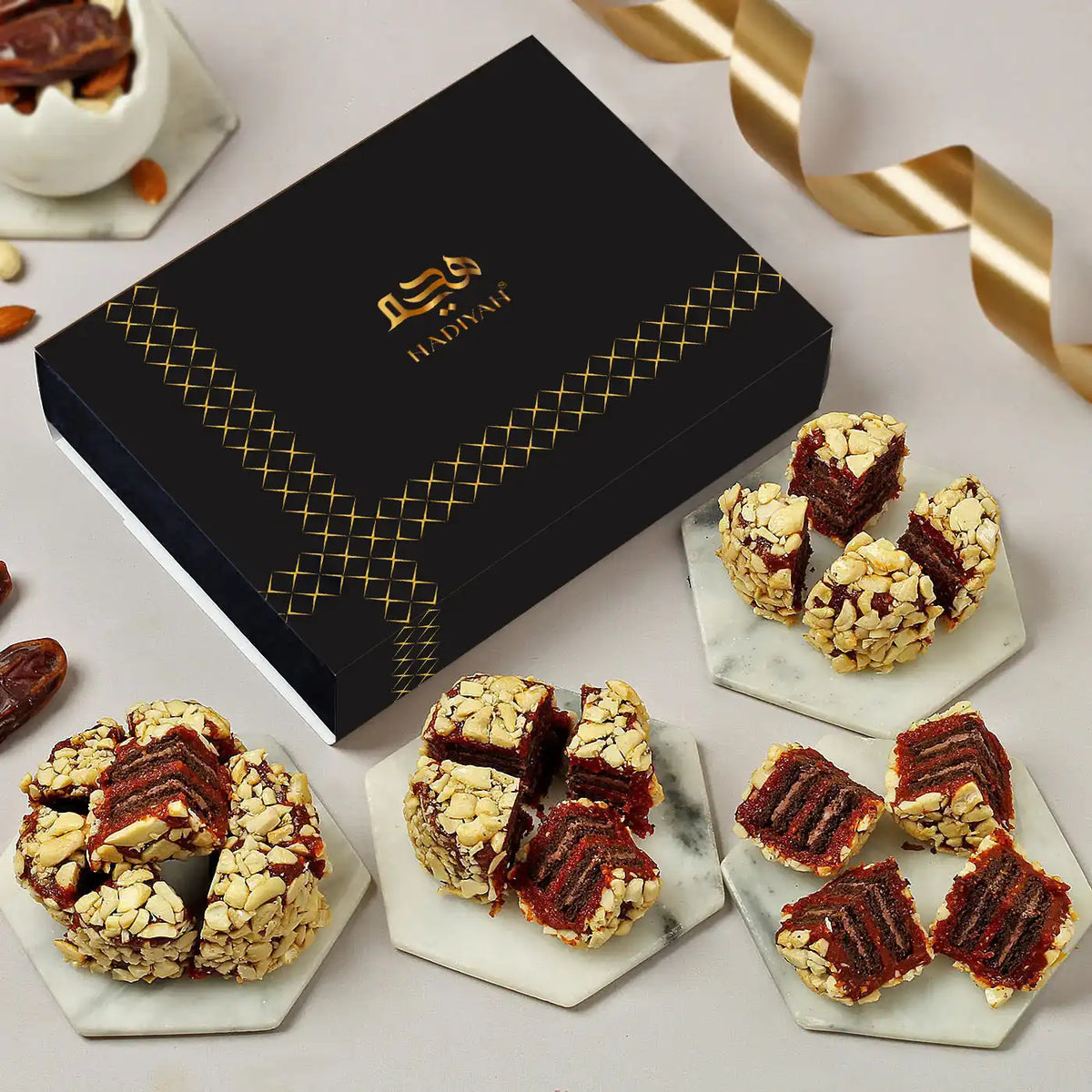 Hassani chocolate truffles on marble plates with a black box featuring the brand name.