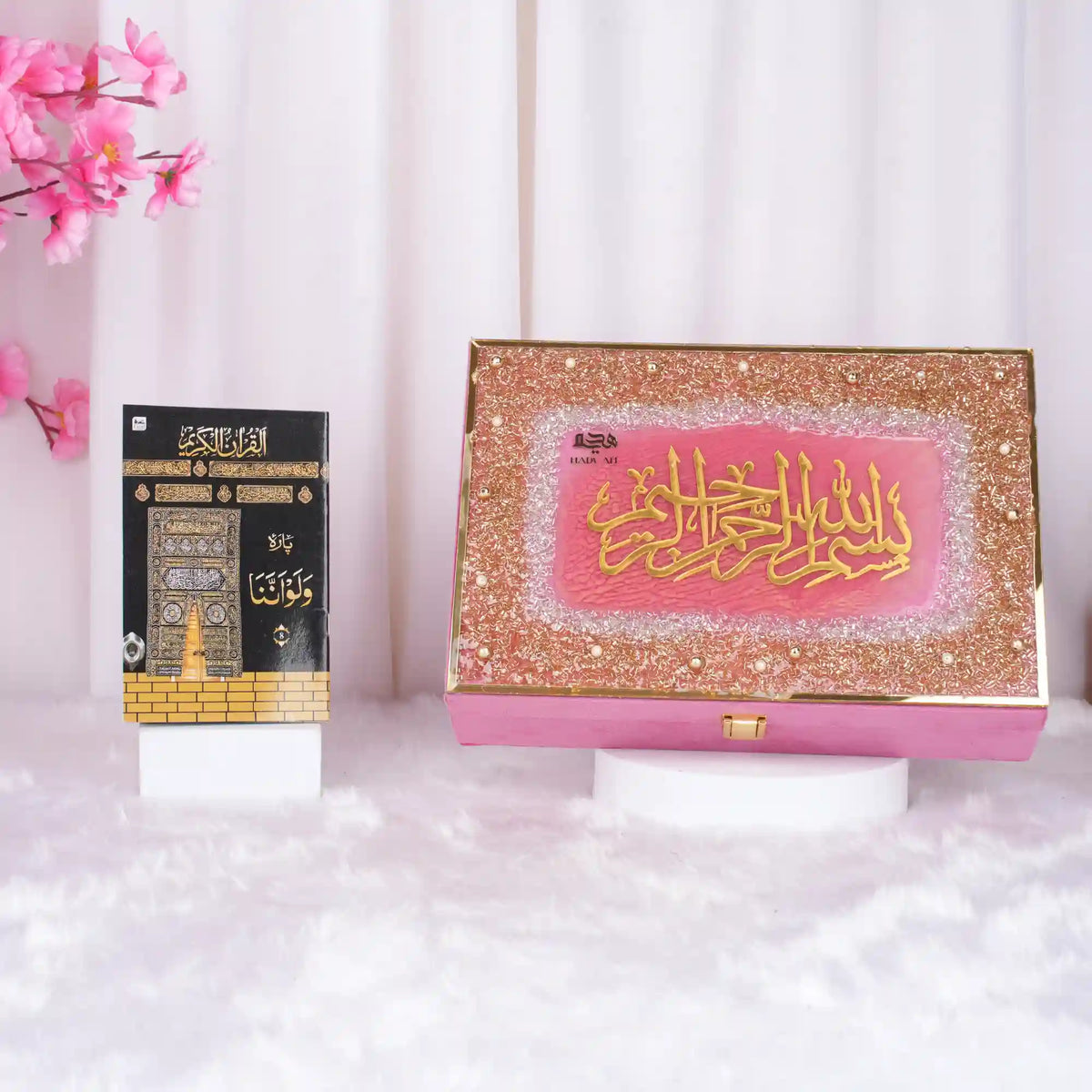 Close-up of Quran with gold calligraphy and pink background