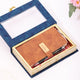 Blue floral gift box with transparent lid and brown leather diary inside