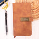 Brown leather diary with gold label inside a blue floral gift box