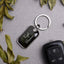 Personalized metal keychain with engraved name on a gray background