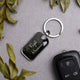 Personalized metal keychain with engraved name on a gray background