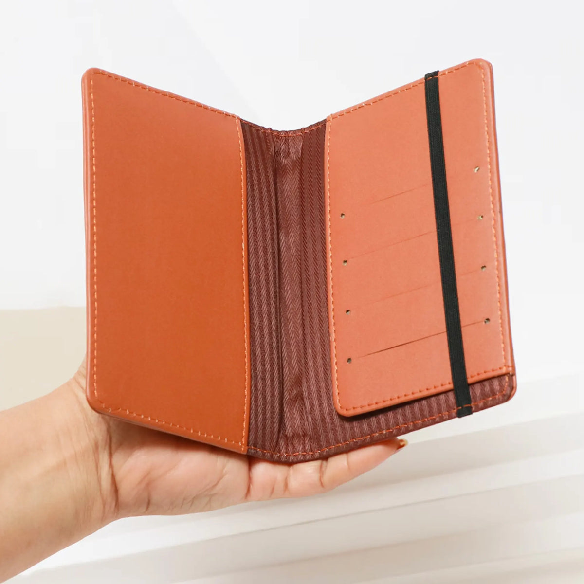 Black passport cover with airplane charm and elastic band