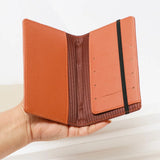Black passport cover with airplane charm and elastic band
