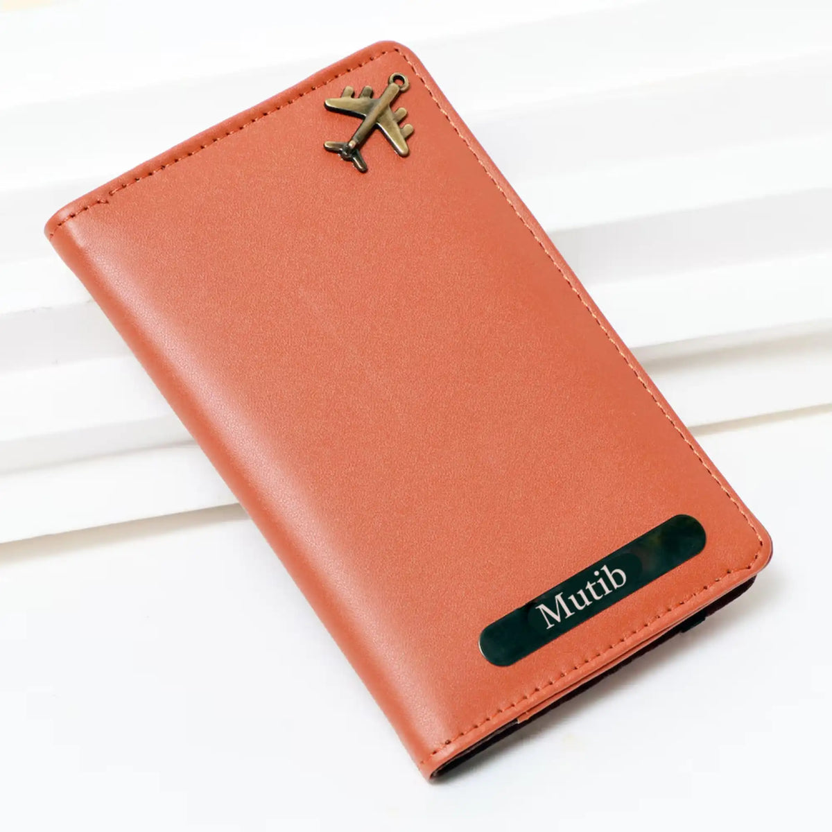 Orange leather passport cover with engraved nameplate