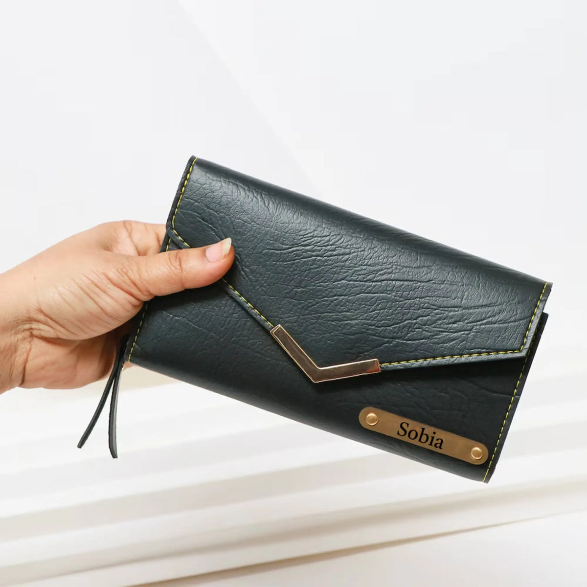 Close-up of black leather clutch with gold accents