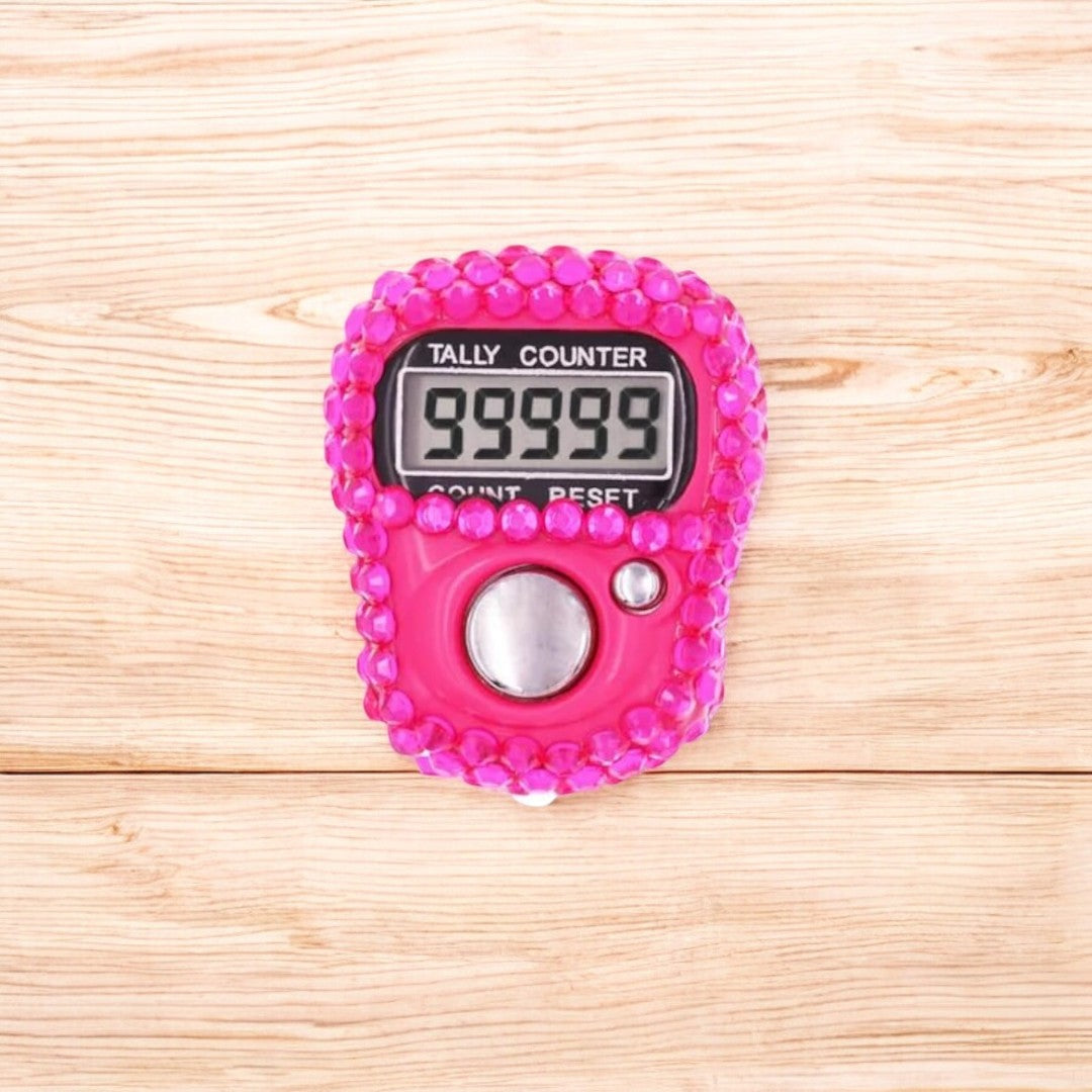 Close-up of pink digital tasbeeh counter with 99999 display. Stylish and modern zikr accessory for gifting.