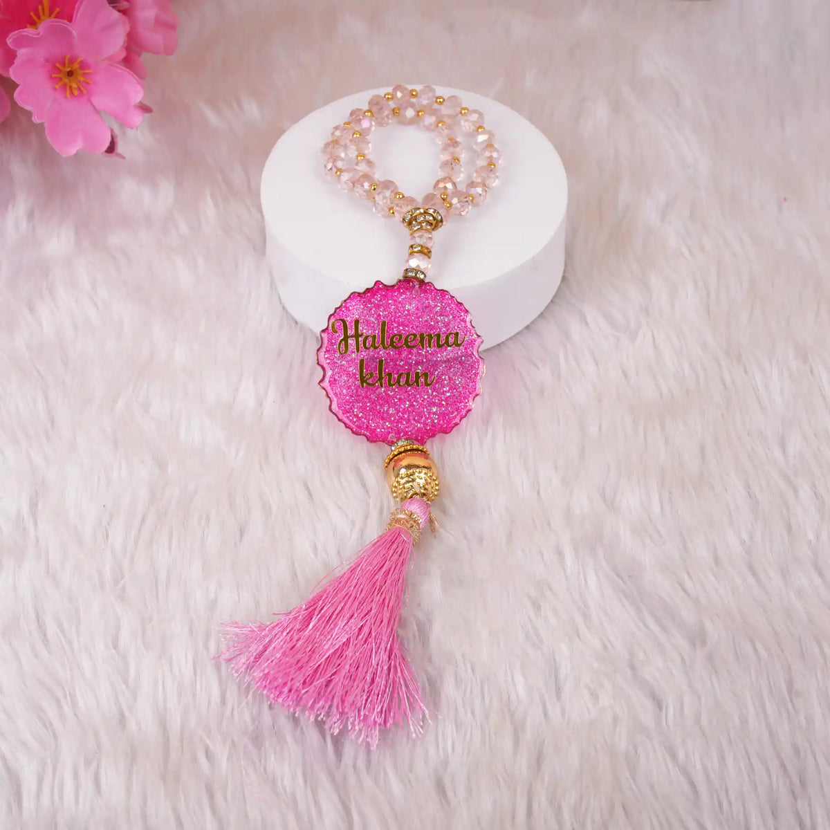 Pink Kids Glitter Tasbeeh with 33 beads and 'Haleema Khan' name tag, adorned with a matching tassel, perfect for Hajj & Umrah gifts for children.