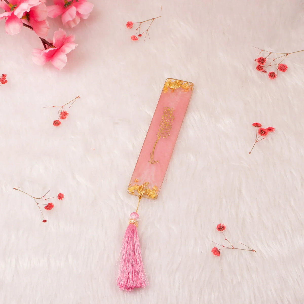 Pink resin Islamic bookmark with gold detailing and tassel, included in the Sawab-e-Jariya bridal hamper. Perfect for Quran reading.