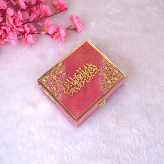 Closed Velvet Mini Quran Set from the Pink Flakes Collection with gold Arabic calligraphy and floral accents on a glossy designer gift box.