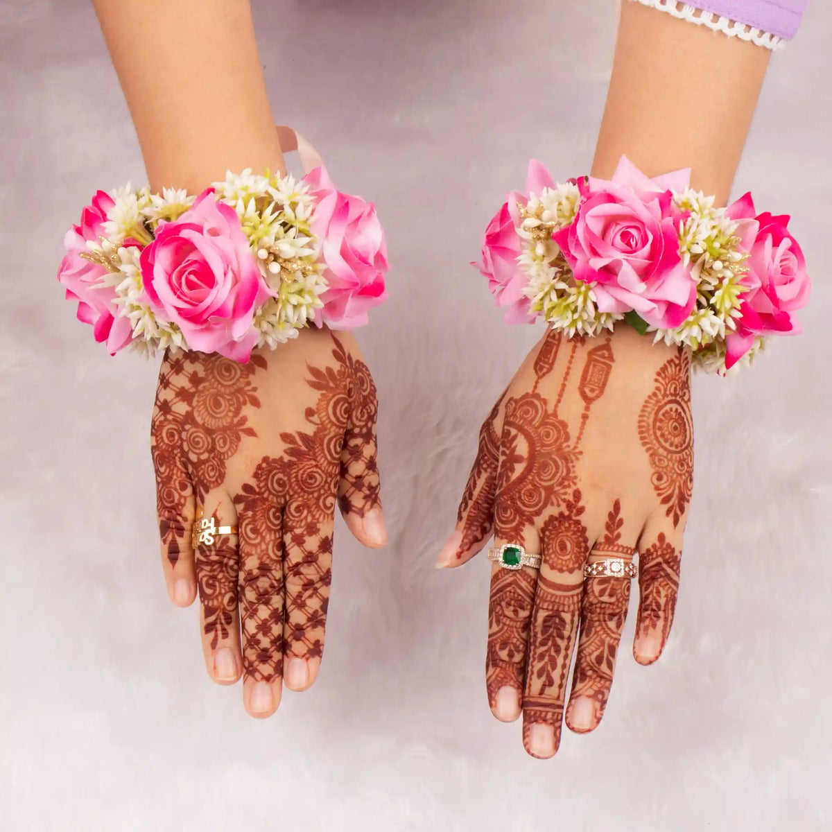 Bridal hands adorned with Handcrafted Pink Floral Gajras and henna, showcasing traditional wedding gifts and Baat Pakki ceremony style.