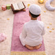 Kids Dome Janamaz - Perfect Prayer Rug for Kids in pink with gold tassels, shown in use by a child during prayer on a soft carpeted floor.