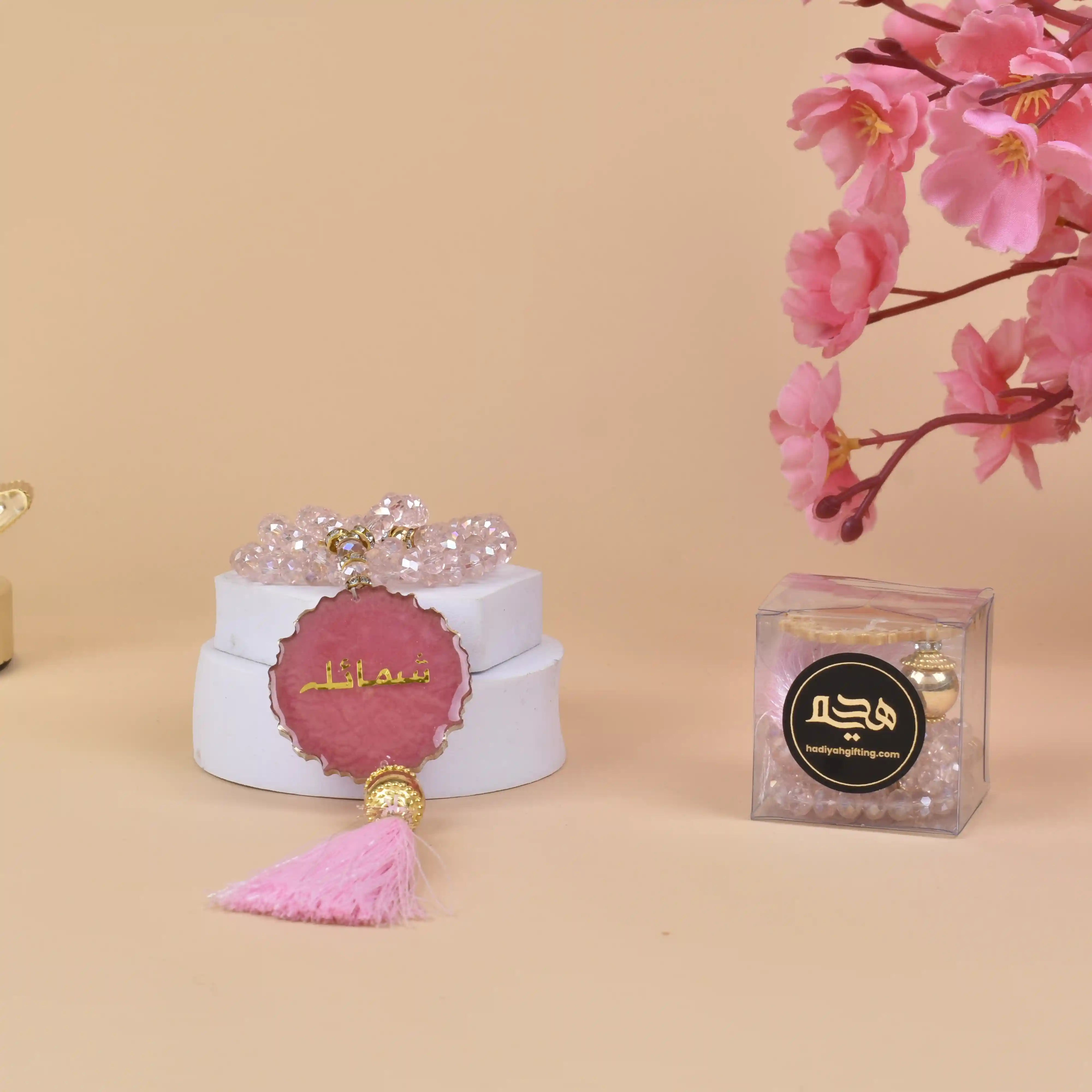 Pink Crystal Tasbeeh Name - Personalized Crystal 100 Beads displayed with floral decor and gift box, ideal for gifting and spiritual use. Main image