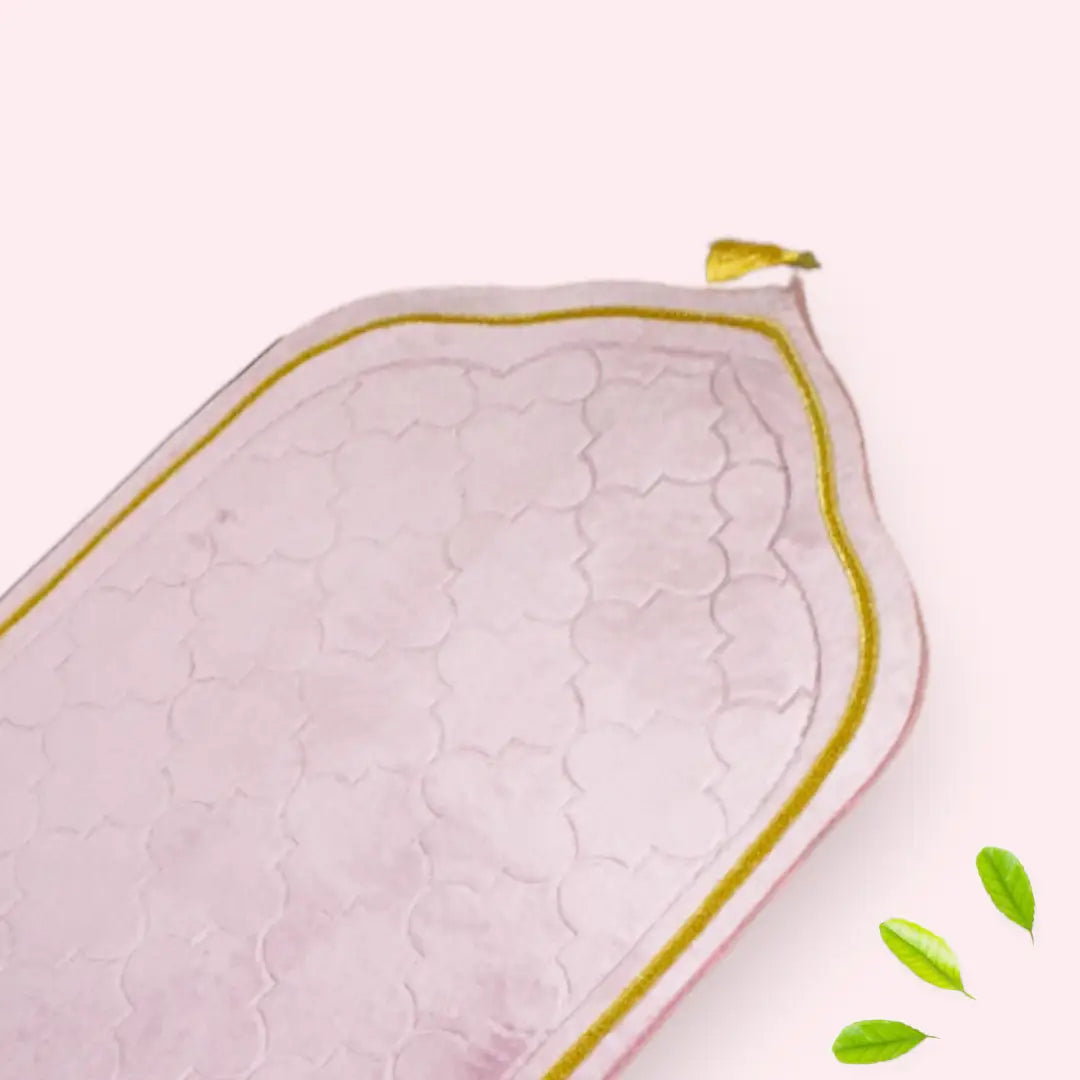 Pink quilt with green leaves on a white background