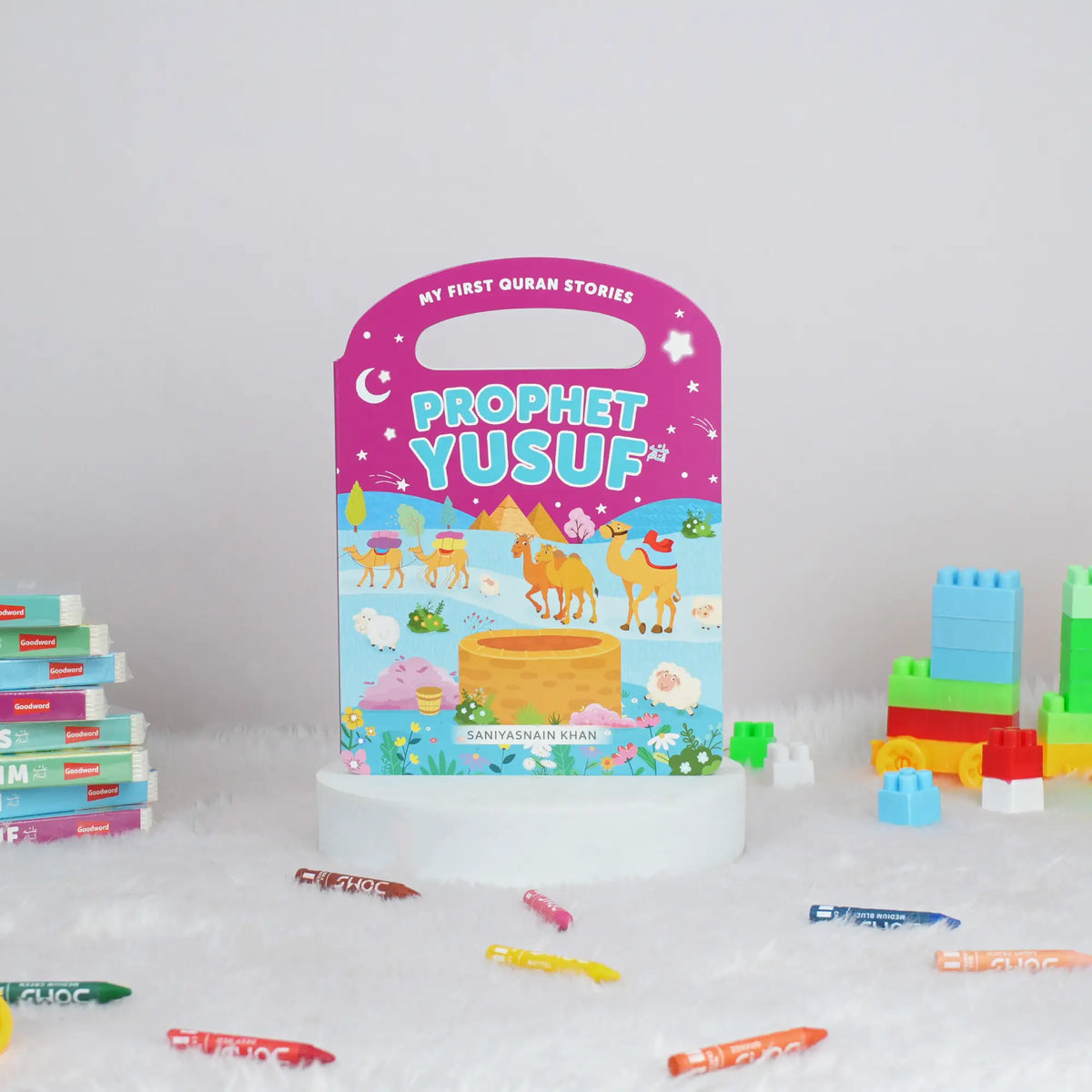 Children's book titled 'Prophet Yusuf' with colorful building blocks and crayons on a white background
