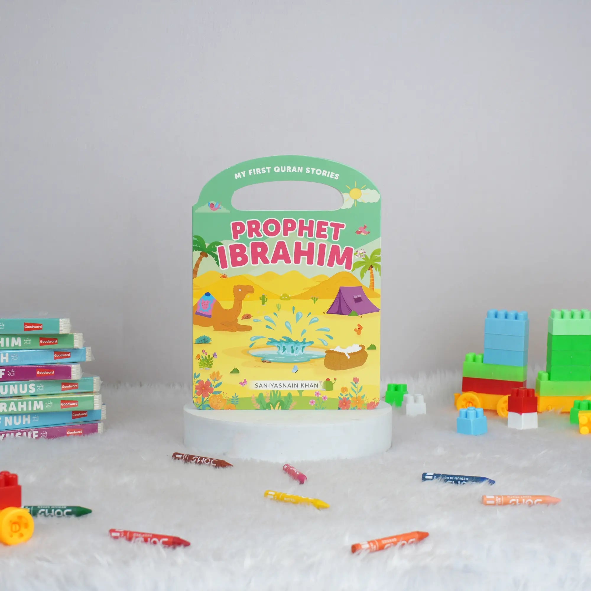 Children's book titled 'Prophet Ibrahim' with building blocks and pens on a white surface