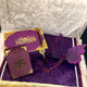 Purple and gold decorative items with a butterfly design on a textured surface