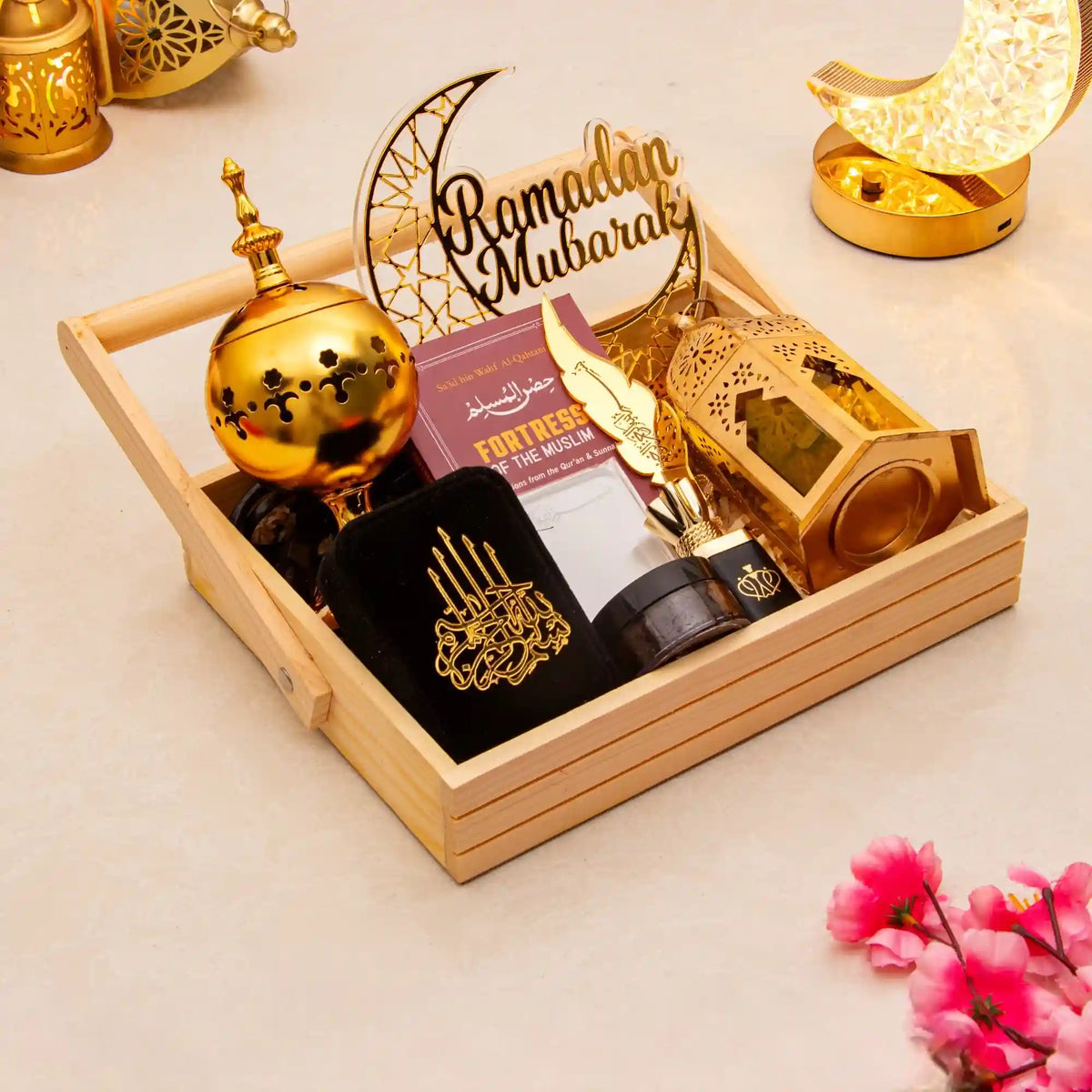 Decorative items for Ramadan on a wooden tray with gold and black colors.