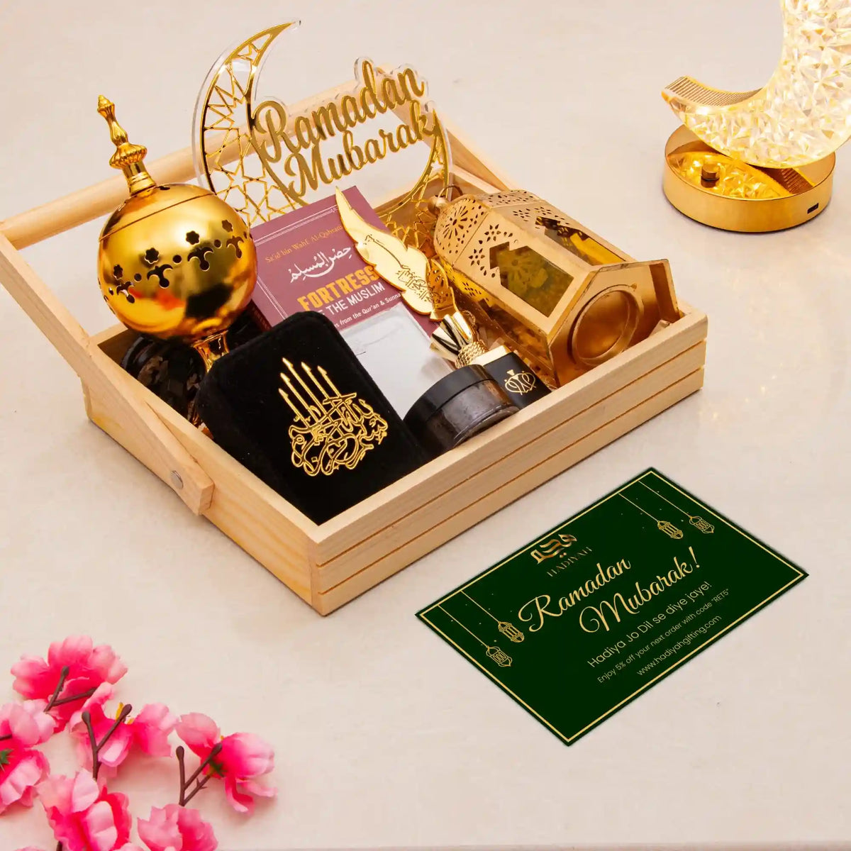 Decorative set with gold lanterns, 'Ramadan Mubarak' sign, and a card on a light background.