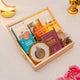 Gift basket with cookies, almonds, and a decorative item on a light surface.