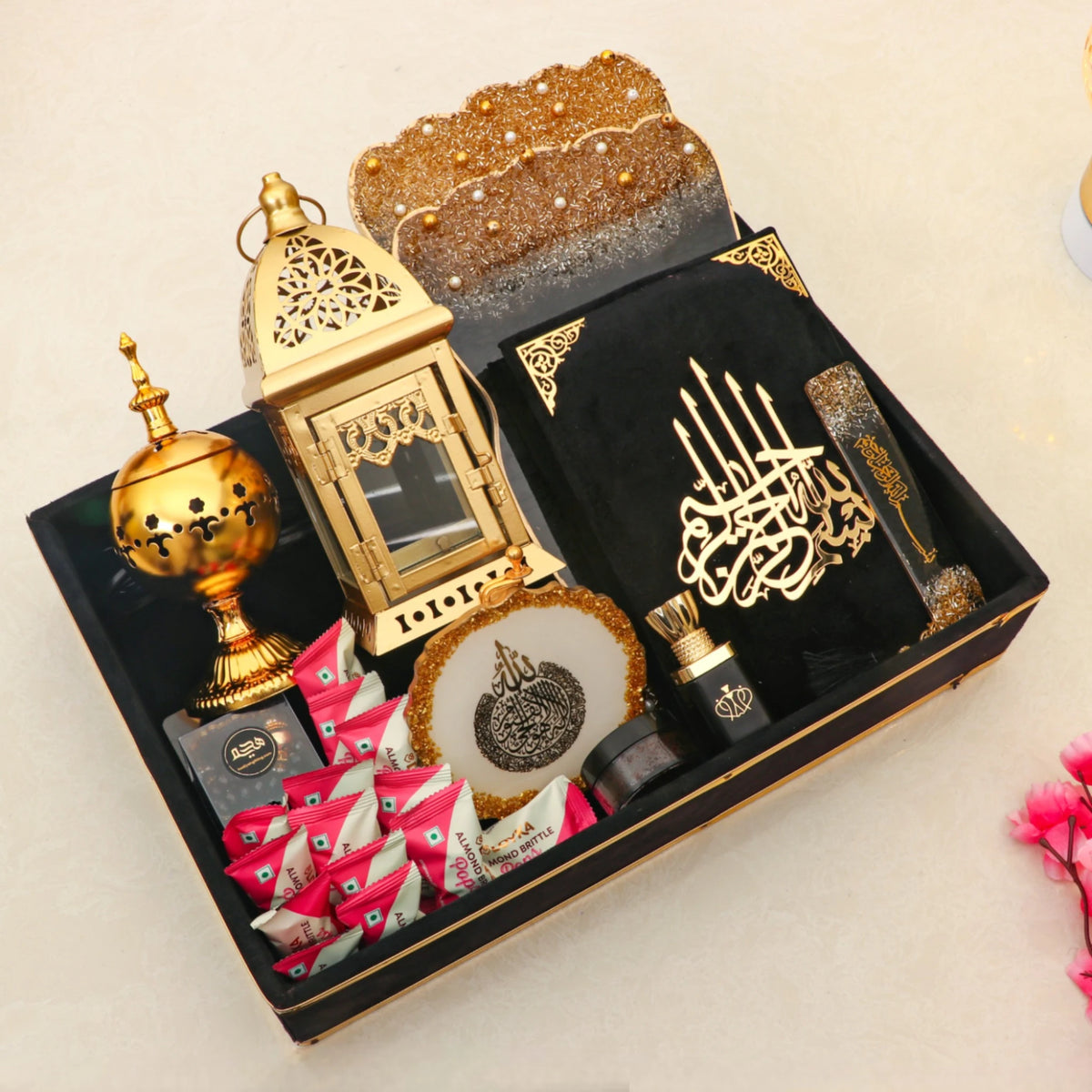 Luxury Ramadan Kareem Hamper Gifts including Quran, golden bakhoor burner, prayer beads, ittar, and assorted sweets in a decorative tray.