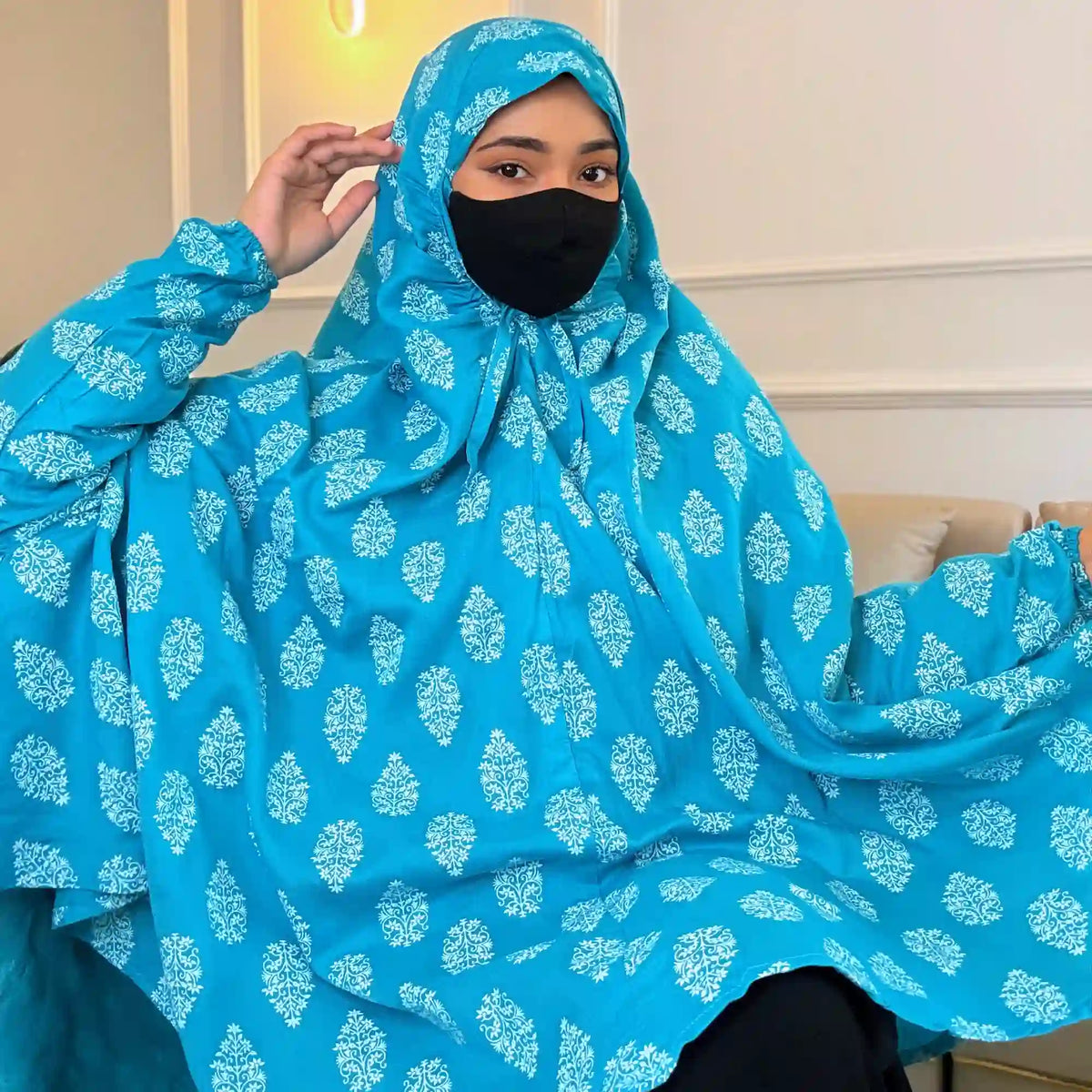 Woman wearing blue printed cotton prayer hijab with black face mask