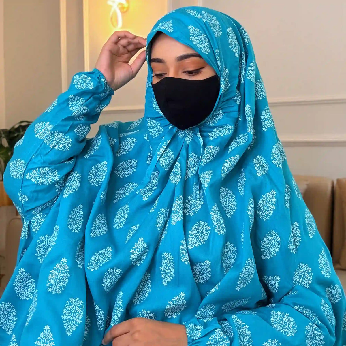 Close-up of woman in blue printed cotton prayer hijab with black mask