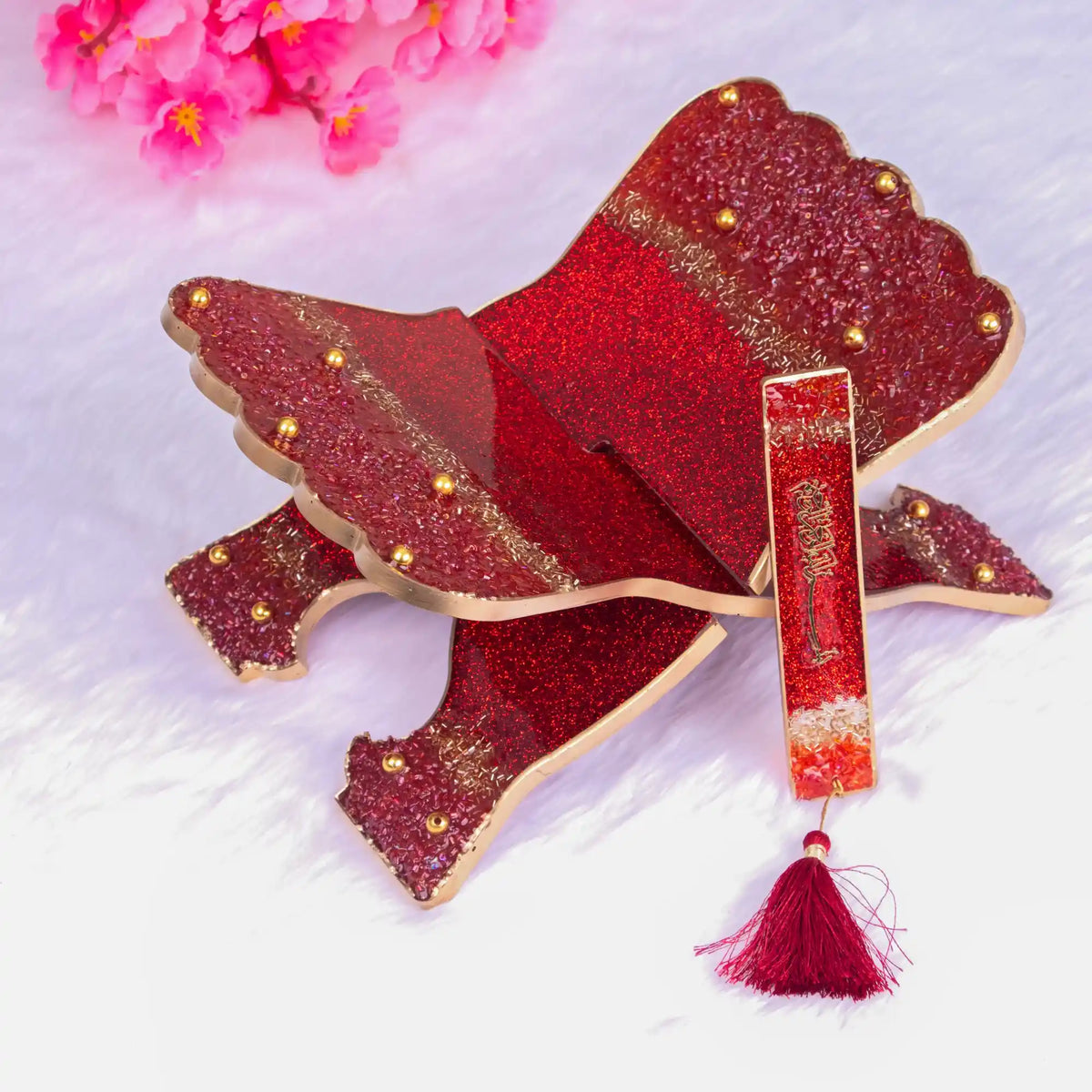 Decorative red and gold item with tassel on a white background