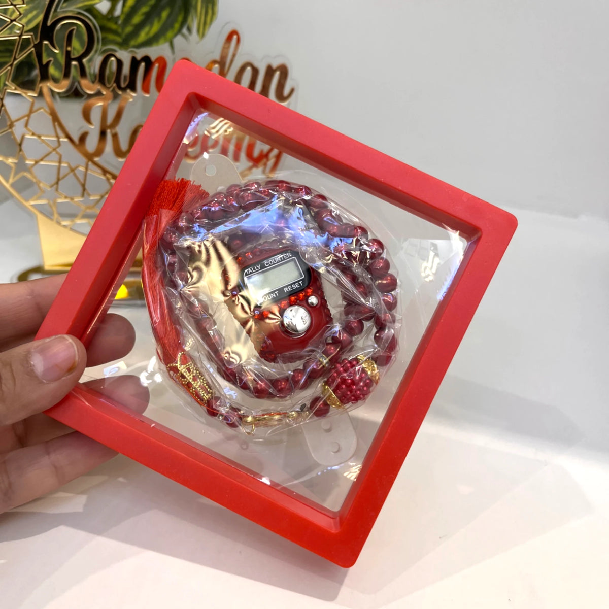 Red Transparent Tasbeeh Combo - Islamic Gifts featuring 100-bead prayer beads and digital counter in a red display box. Ideal for Ramadan or Eid gifting.