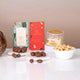 Close-up of Red Velvet Blessings Hamper contents including caramel treats, choco-almonds, and roasted cashews for festive gifting.