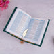 Open book with a decorative leaf bookmark on a light pink surface with pink flowers.