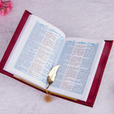 Open Velvet Quran Translation in red with bilingual Arabic-English text and gold feather bookmark, perfect for religious gifting.