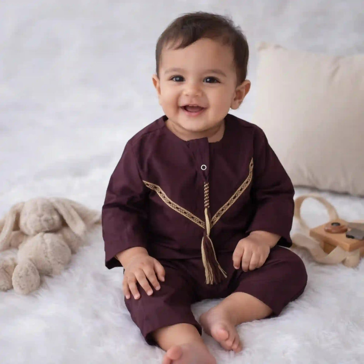 Baby boy wearing maroon thobe romper with gold detailing, ideal for Eid gifts and Islamic festive wear in the Kids Collection.