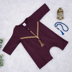 Flat lay of maroon thobe romper for baby boys featuring gold Omani style trim, soft fabric, and easy snaps for diaper changes.