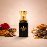 Luxurious Shanaya attar in a black and gold bottle, surrounded by raw fragrance ingredients including a red rose, smoking resin, spices, and honey.