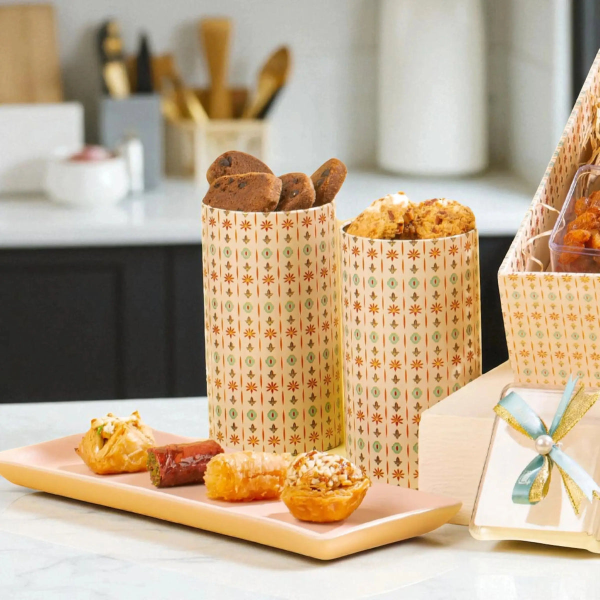 Artisan cookies and sweets from the Sadaqah Sweets Festive Hamper displayed in patterned containers, ideal for gourmet food gift baskets.