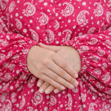 Close-up of pink printed fabric with hands folded