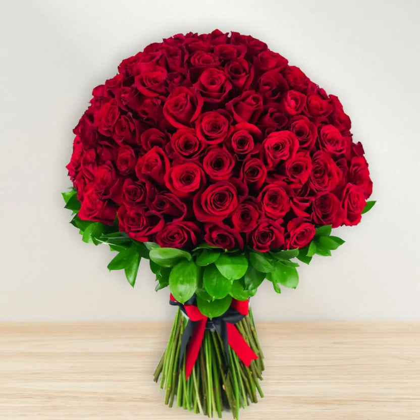 Enigmatic Love Red Roses Bouquet featuring lush, deep red roses tied with a red and black ribbon. Ideal romantic flower gift for anniversaries or Valentine's Day. Main image