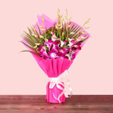 Purple Orchid Bouquet wrapped in vibrant pink paper with white ribbon, ideal for anniversaries or same day delivery gifts.