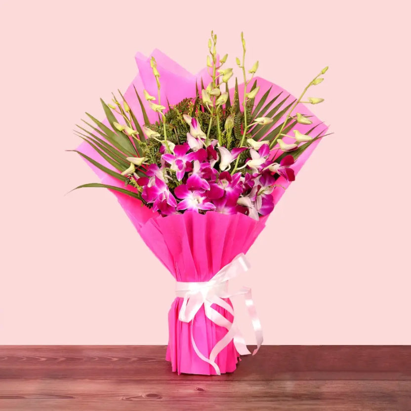 Purple Orchid Bouquet wrapped in vibrant pink paper with white ribbon, ideal for anniversaries or same day delivery gifts. Main image
