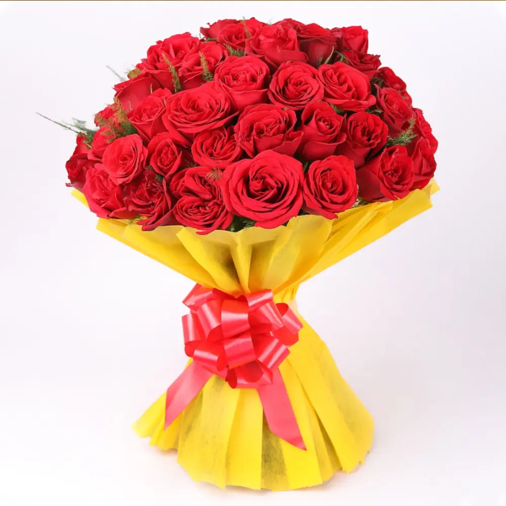 Red Roses Romantic Bouquet with lush red blooms in yellow wrapping and red ribbon, perfect for expressing love and same day flower delivery.