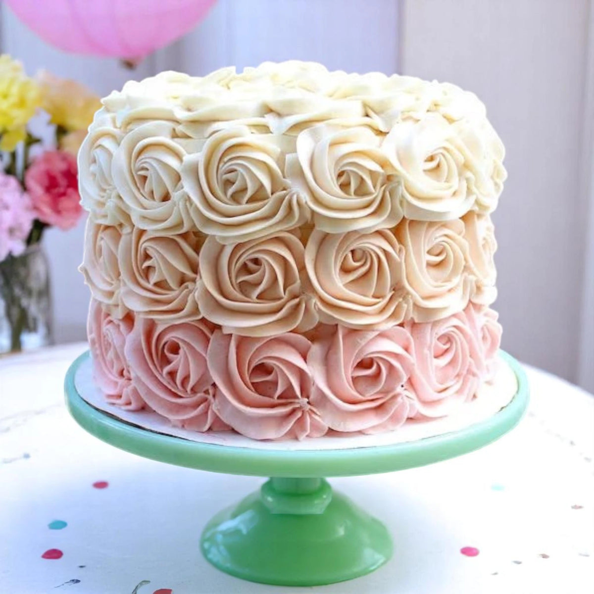 Rose Pattern Cake with creamy layered frosting in gradient shades, displayed on a pastel green stand. Perfect for celebrations and same day delivery.